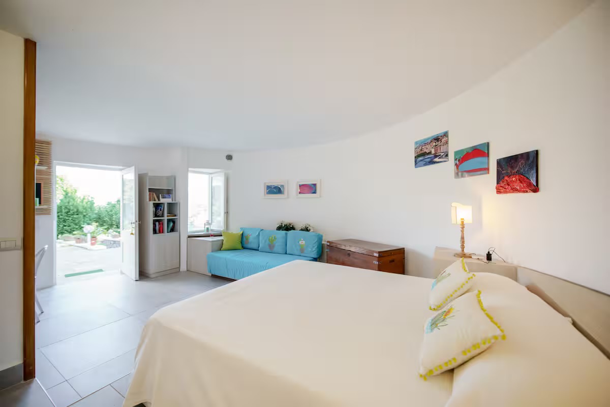 L'ambiente visto dal letto, con la porta aperta sul giardino